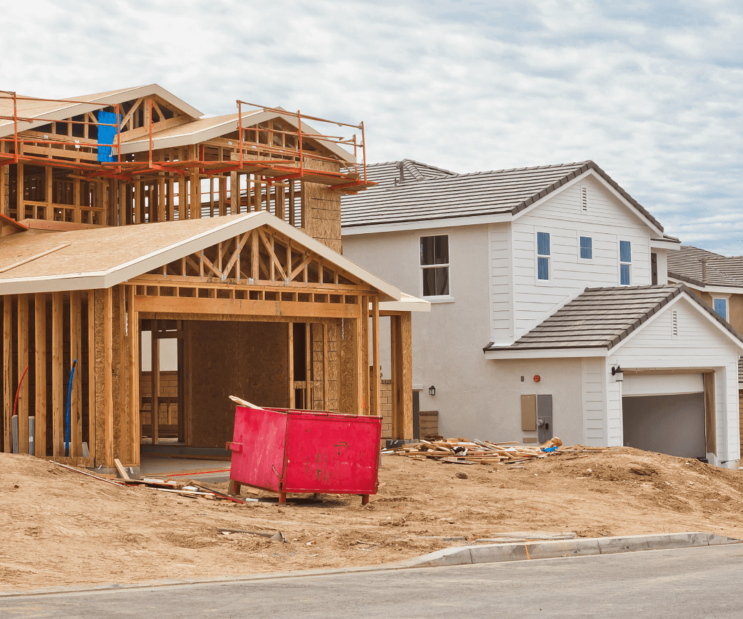 House under construction beside completed home.