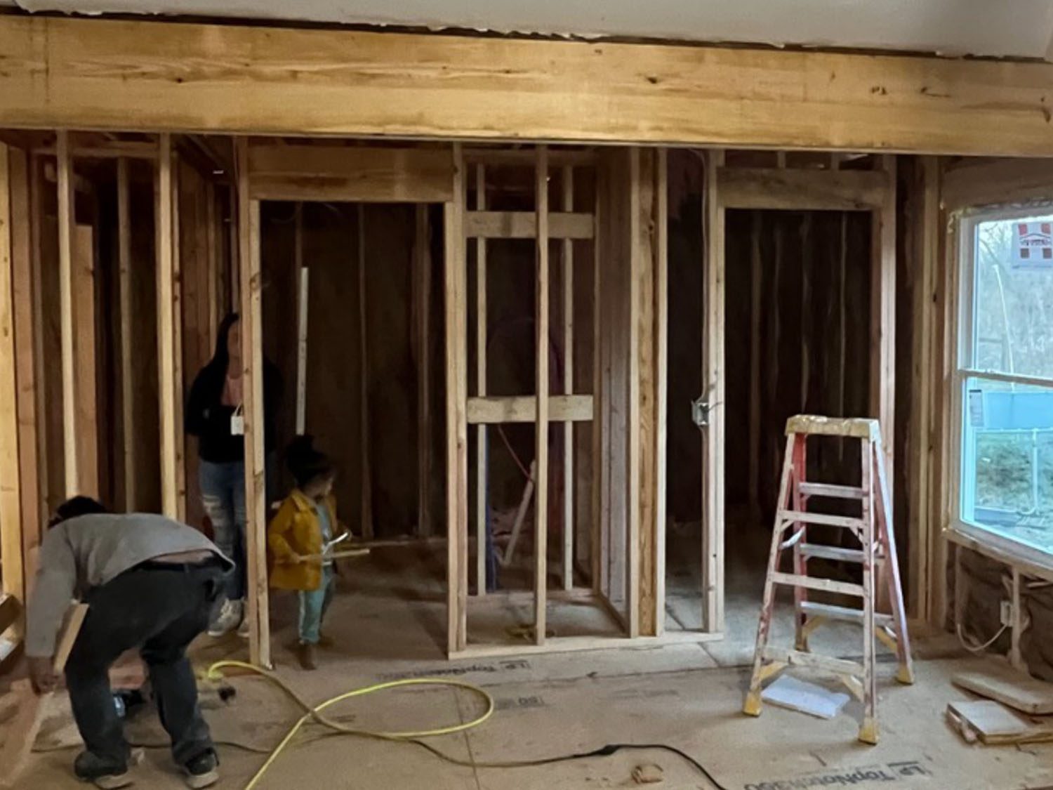 Room under construction with wooden framing and tools scattered.