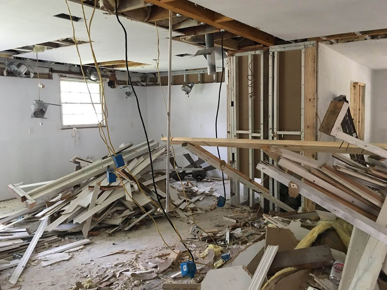 Room under heavy renovation with exposed walls and debris scattered.